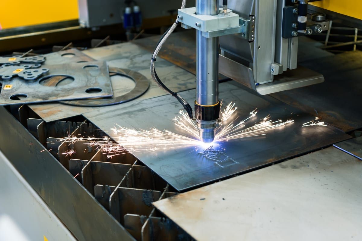 Máquina CNC de corte por plasma cortando piezas en una chapa de acero